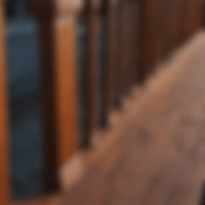 Close-up of hand staining wooden deck railing with rich mahogany paint