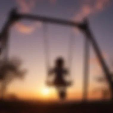 Silhouette of a child against the sunset sky on a swing set